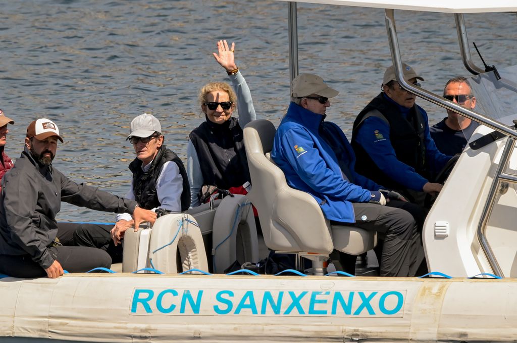 La infanta Elena saludando desde su embarcación en la costa de Sanxenxo, junto a su padre