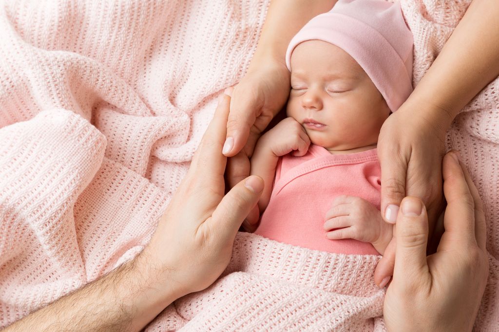 Bebé recién nacido entre los brazos de sus padres