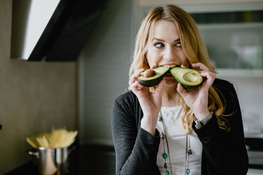 Mujer comiendo aguacate