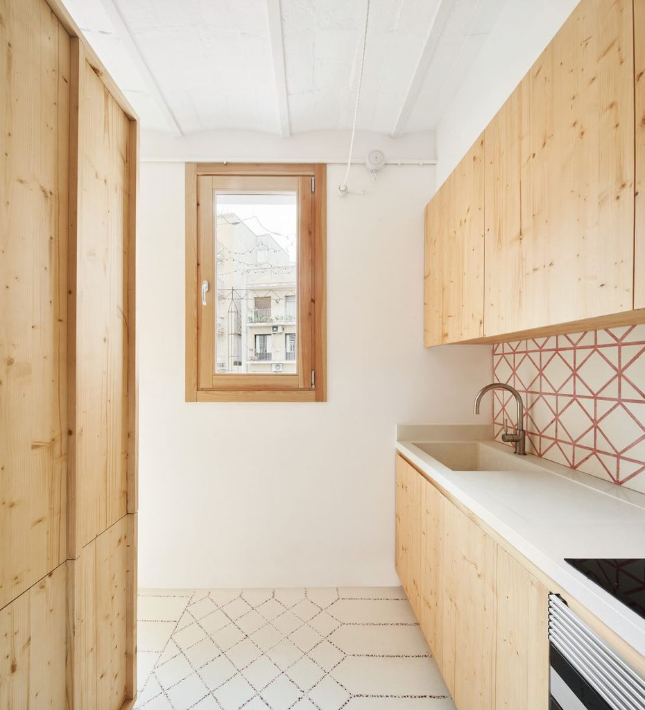 Cocina con muebles de madera clara y revestimientos en hidráulicos de Huguet