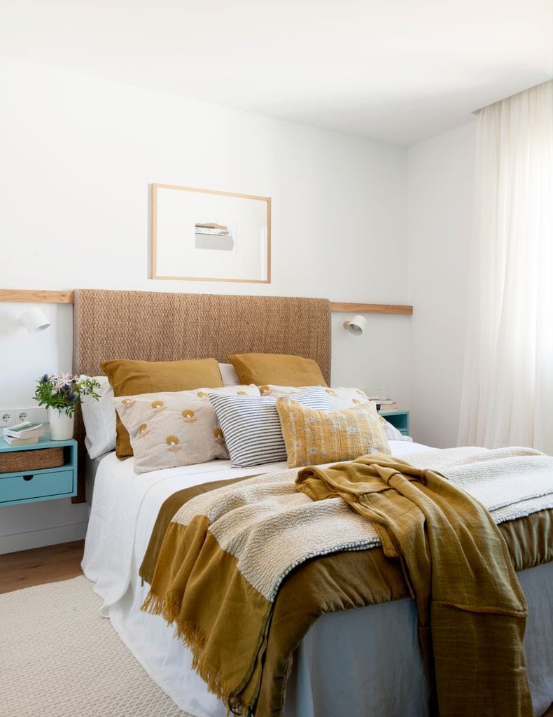 Dormitorio con alfombra a modo de cabecero. 