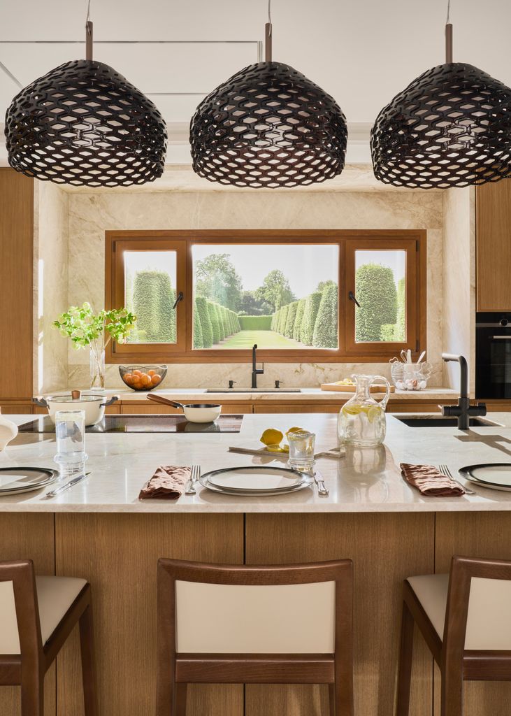 Isla de cocina iluminada con tres lámparas colgantes