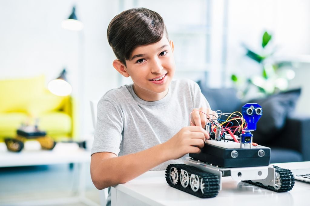 Niño construyendo un robot en campamento de robótica