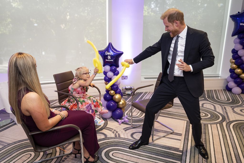 El príncipe Harry se puso a jugar con una niña, usando globos en forma de espadas. 