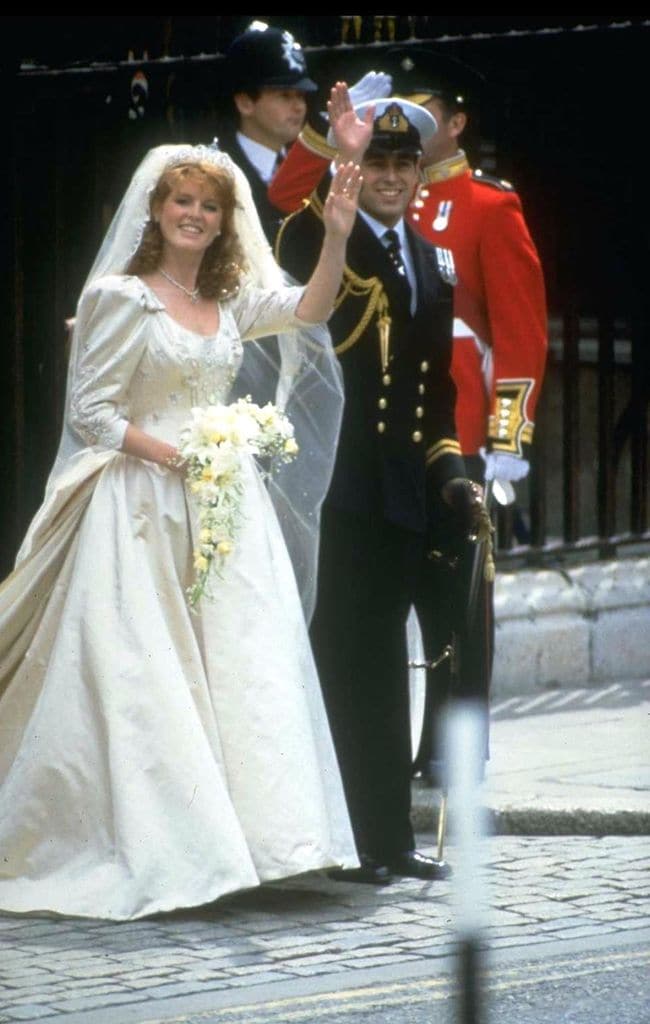Prince Andrew, the Duke of York, and Sarah Ferguson wave outside of Buckingham Palace on their wedding day, London, England, July 23, 1986. (Photo by Hulton Archive/Getty Images) 