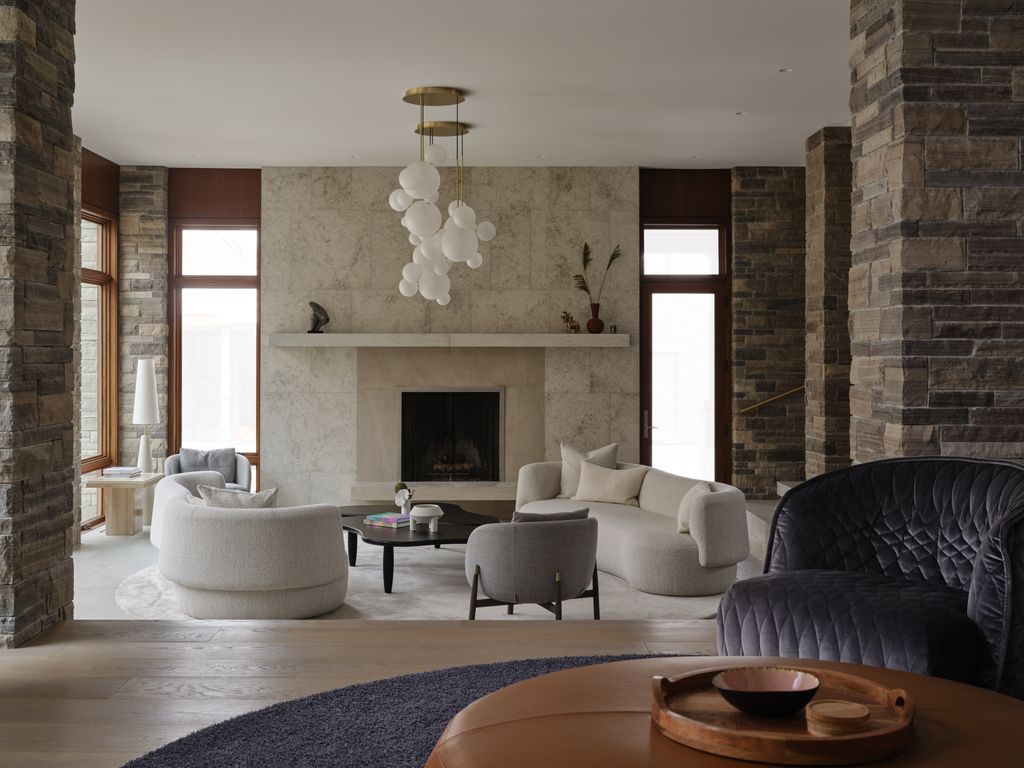 Salón con sofás curvos, chimenea y lámpara de techo