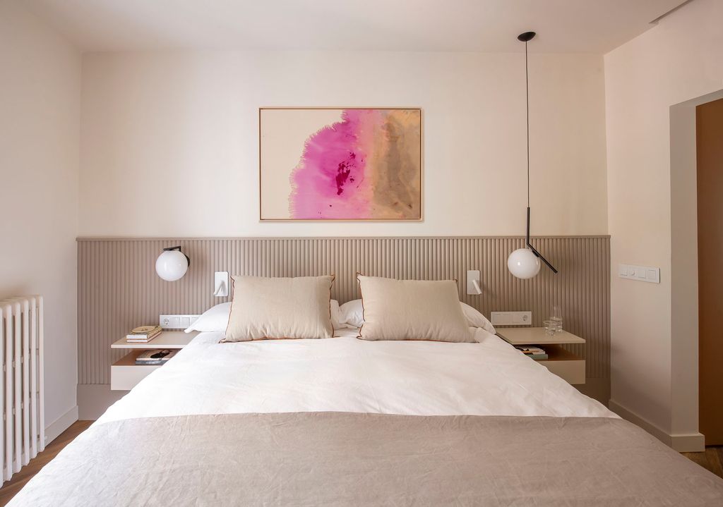 Dormitorio con un cuadro que aporta un toque vital en fucsia