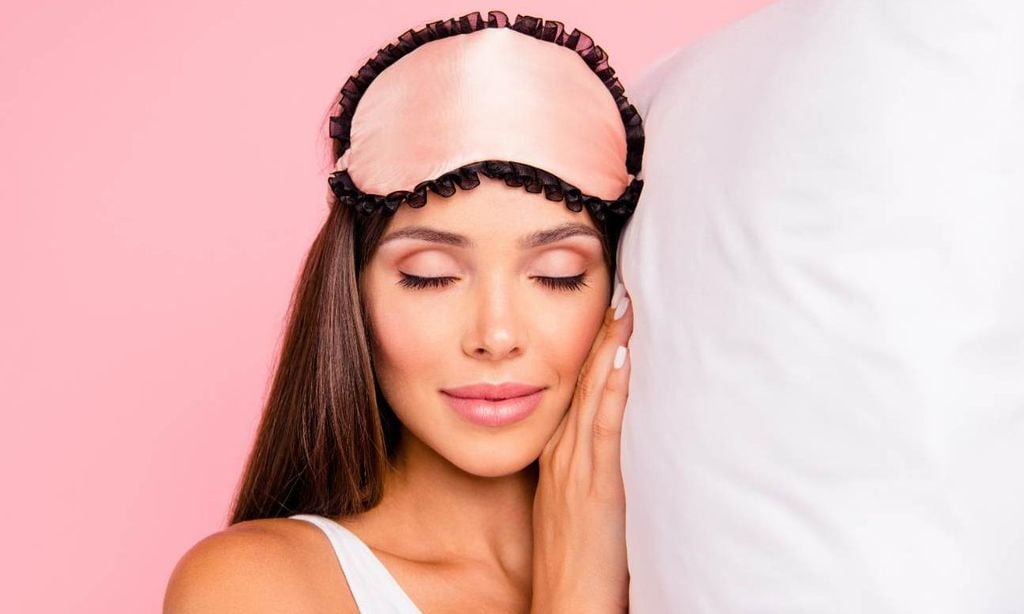 Joven con almohada y tapaojos rosado