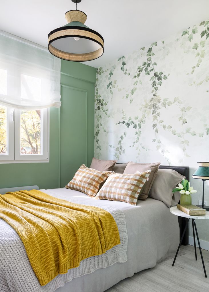 Dormitorio con pared del cabecero decorada con papel pintado