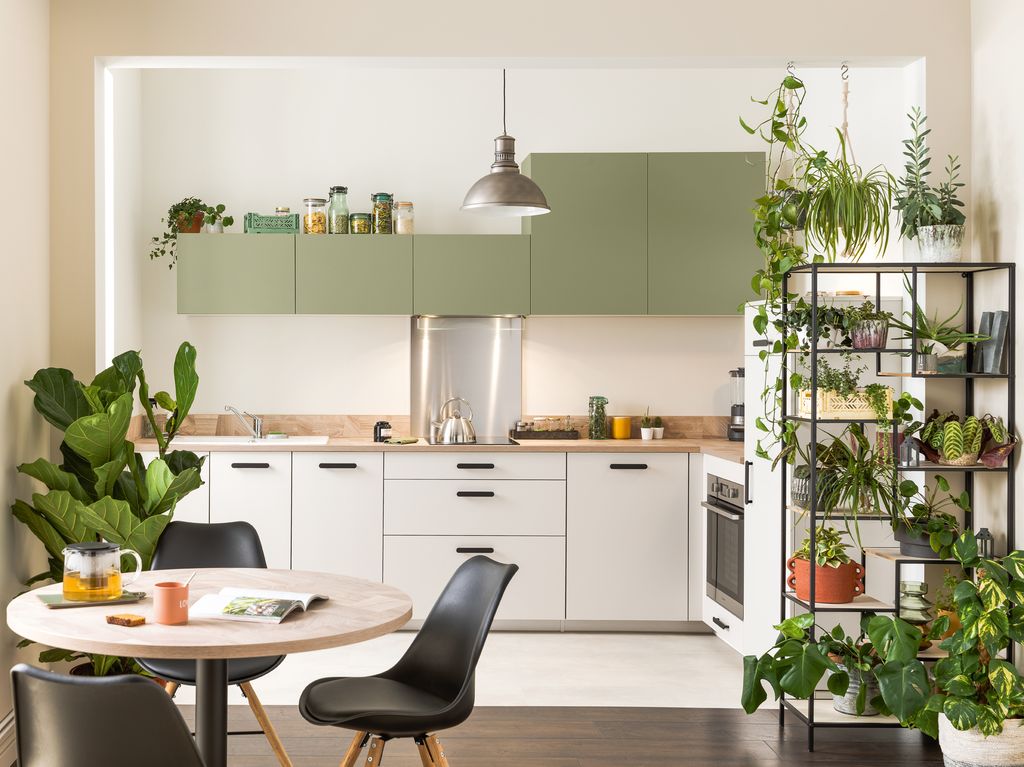 Cocina con armarios en color blanco en los módulos inferiores y verde en los superiores