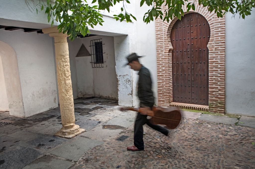 Callejuela de la Judería de Córdoba y músico paseando
