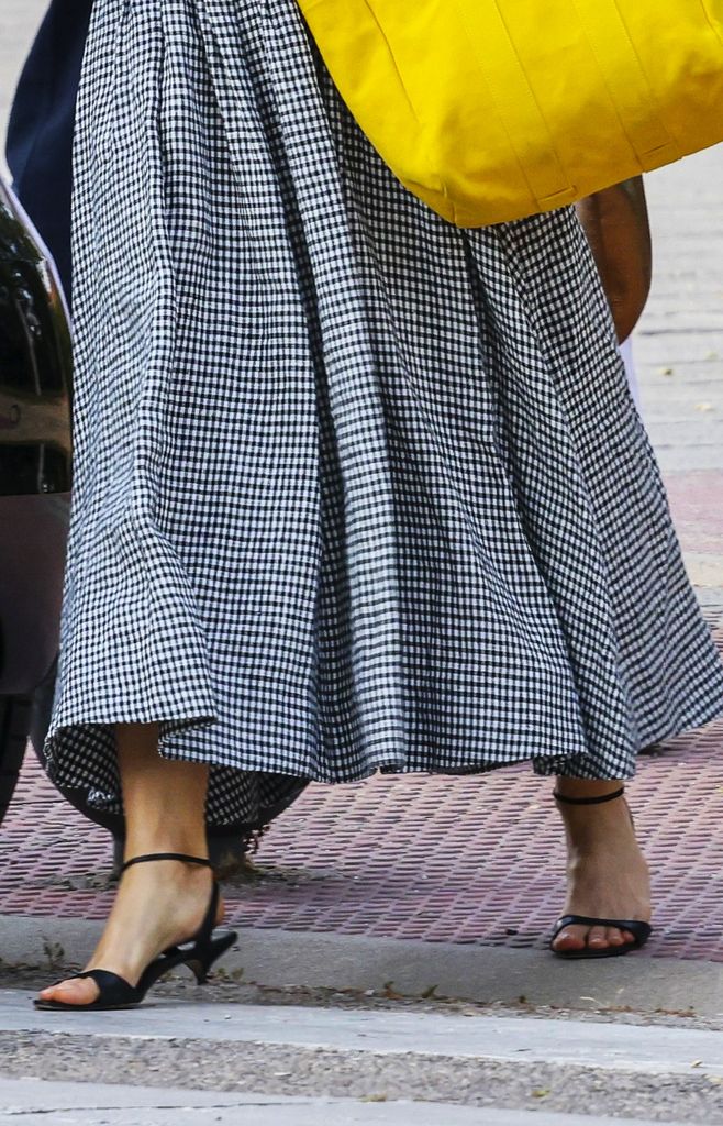 Carolina Herrera en la graduación de su hija en Madrid con vestido de cuadros vichy y bolso amarillo.