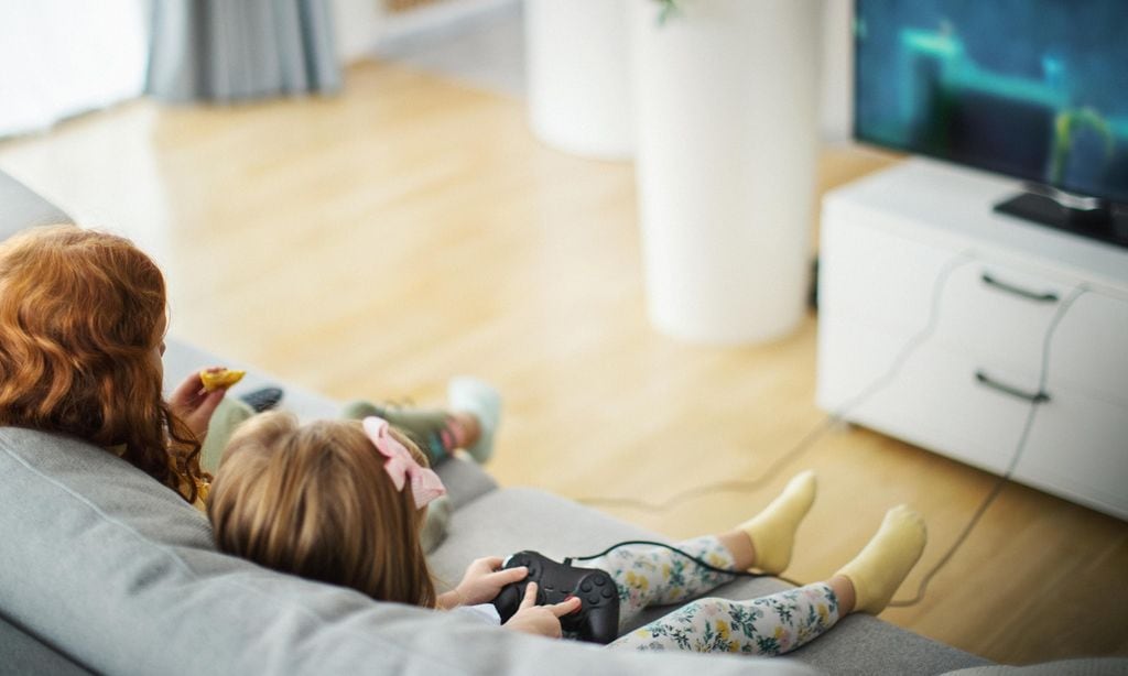 Little girls playing video games at home.