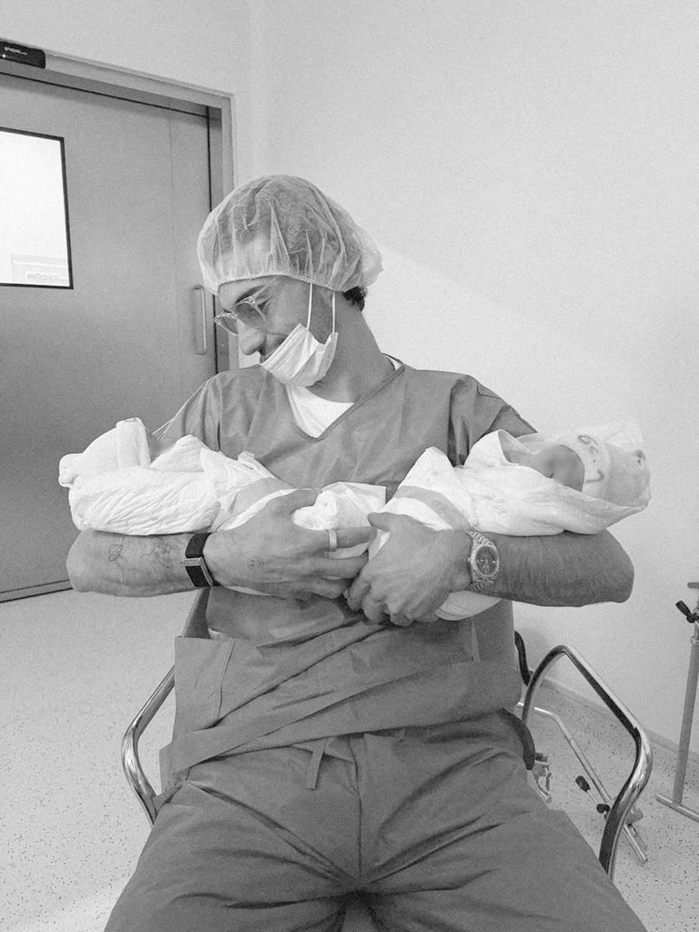 Juan sostiene en brazos a sus dos hijos