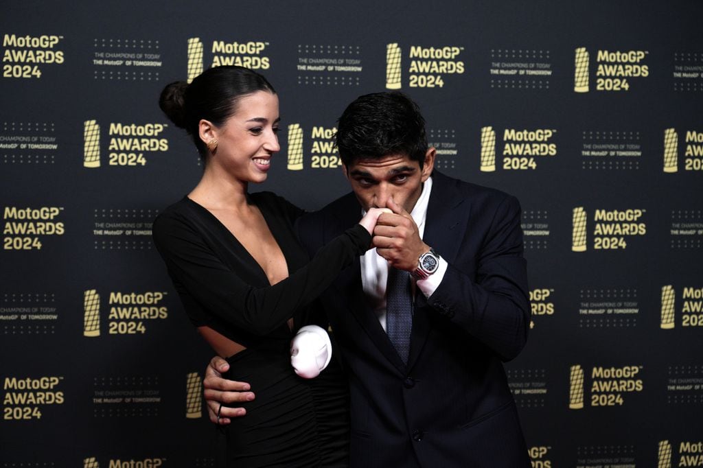 Plano medio de Jorge Martín besando la mano de María Monfort en el photocall