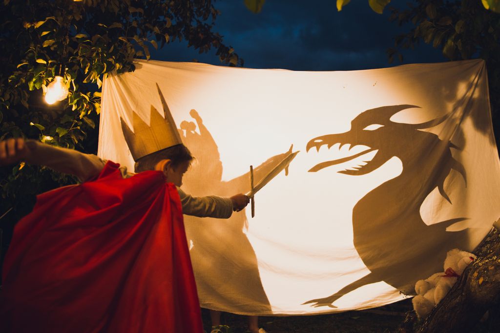 Niño haciendo un teatro de sombras