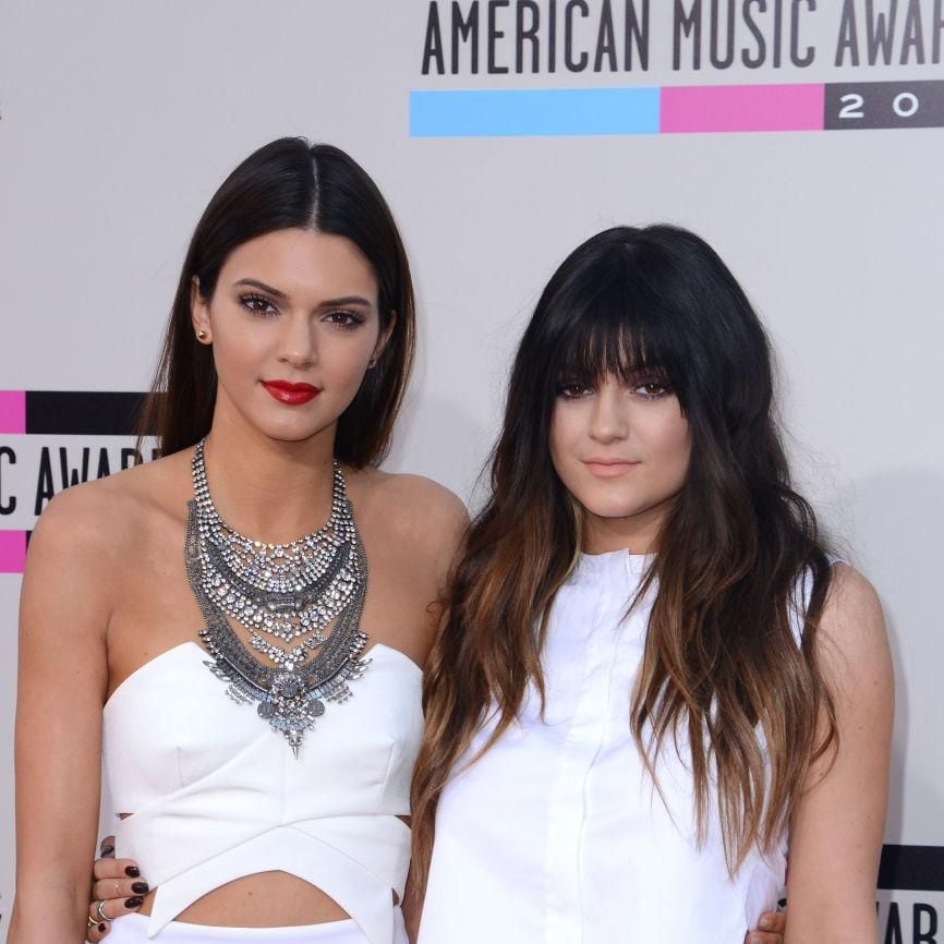 kendall jenner con cabello liso y labios rojos y kylie jenner con flequillo cabello con puntas claras y maquillaje nude