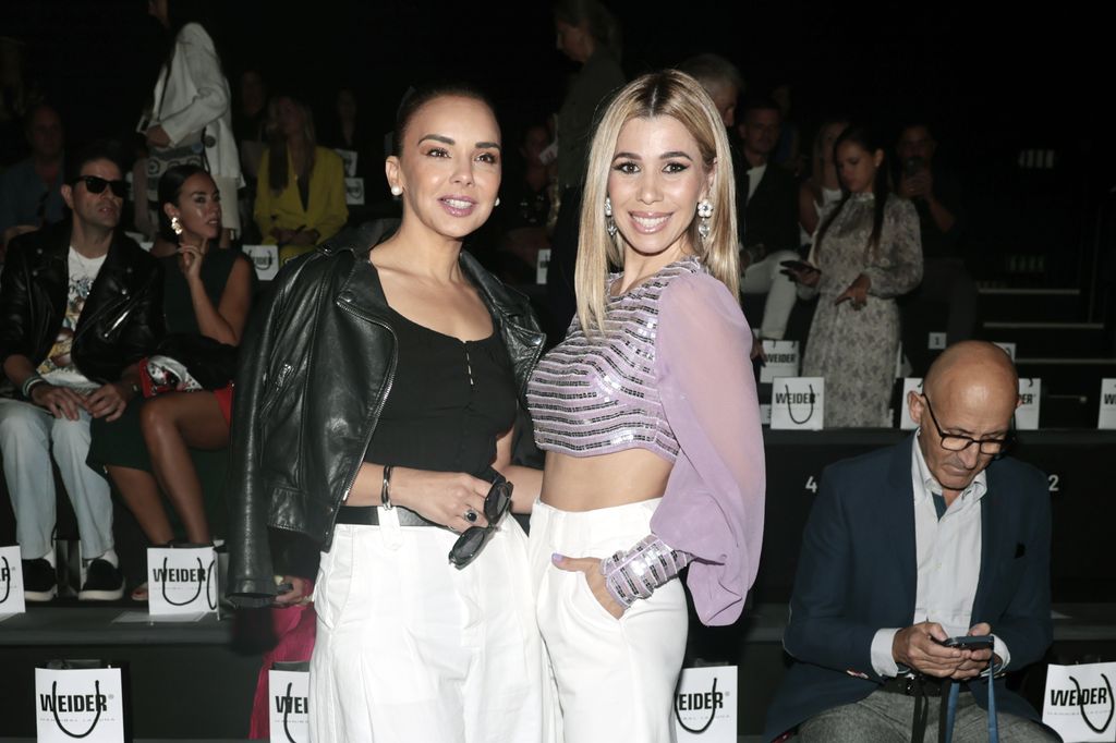 Chenoa y otra mujer posan juntas en un evento, sonriendo.