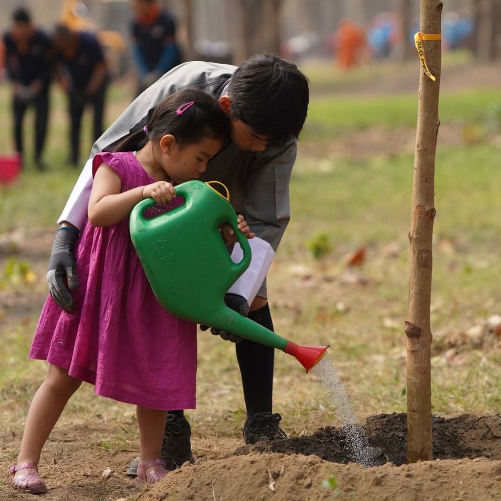 La pequeña Princesa Dragona, junto a su hermano, el príncipe heredero, plantando un árbol
