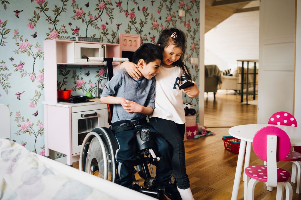 Hermanos juntos, uno de ellos en silla de ruedas