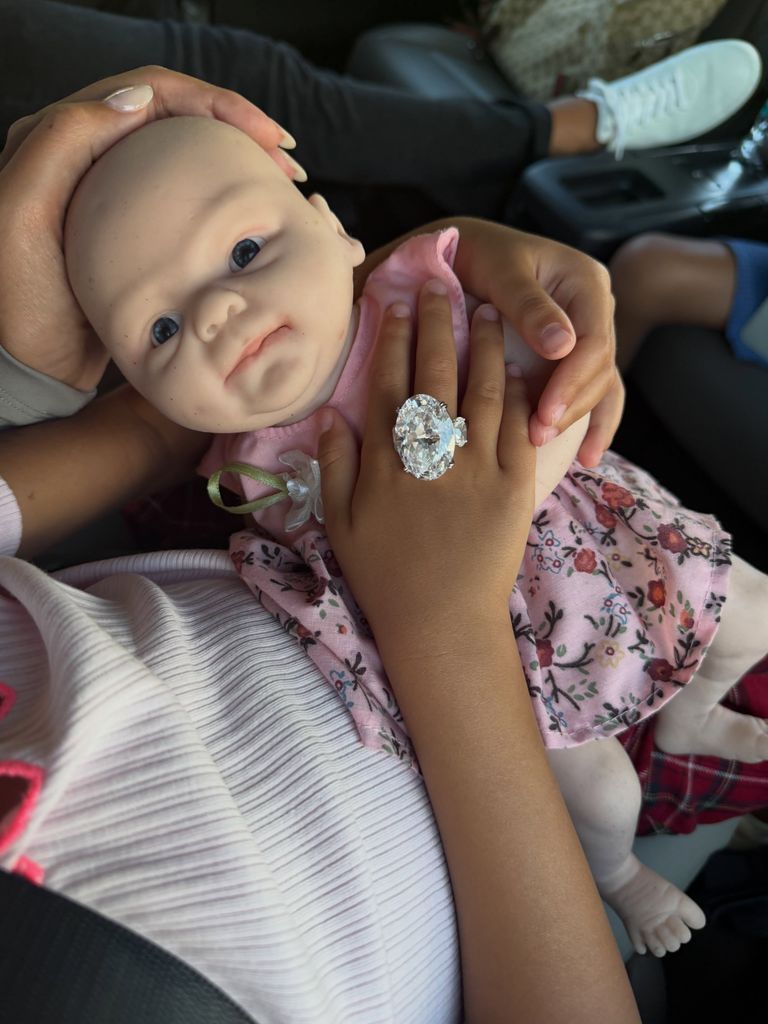Una de las hijas de la pareja lució el anillo de compromiso de mamá mientras cargaba a su muñeca