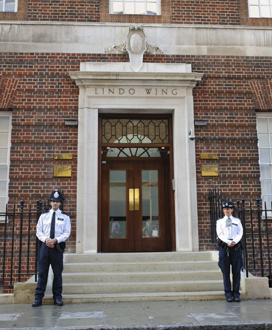 Dos policias escoltan la puerta de la maternidad del hospital St. Mary, donde el príncipe Guillermo nació hace 31 años, a la espera que nazca el bebé de los Duques de Cambridge