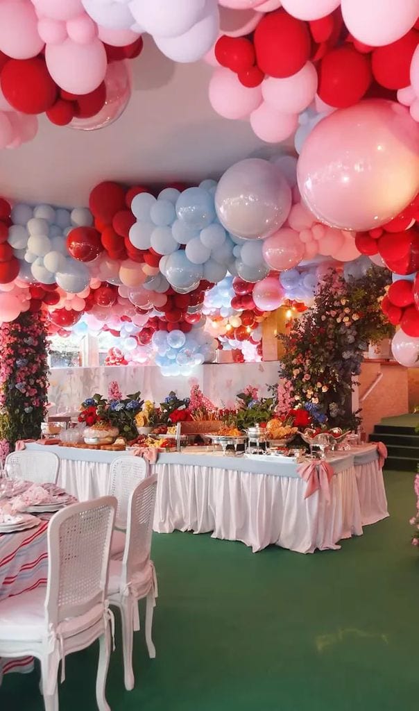 Las mesas estaban cubiertas con estampados florales y globos caían en cascada desde el techo en tonos pastel de rosa, azul y rojo.