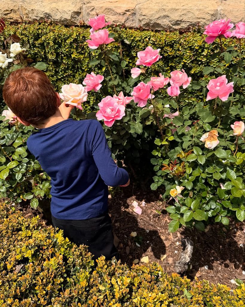 Archie Harrison observando las rosas del jardín de su casa, en compañía de su mamá y su hermana Lilibet