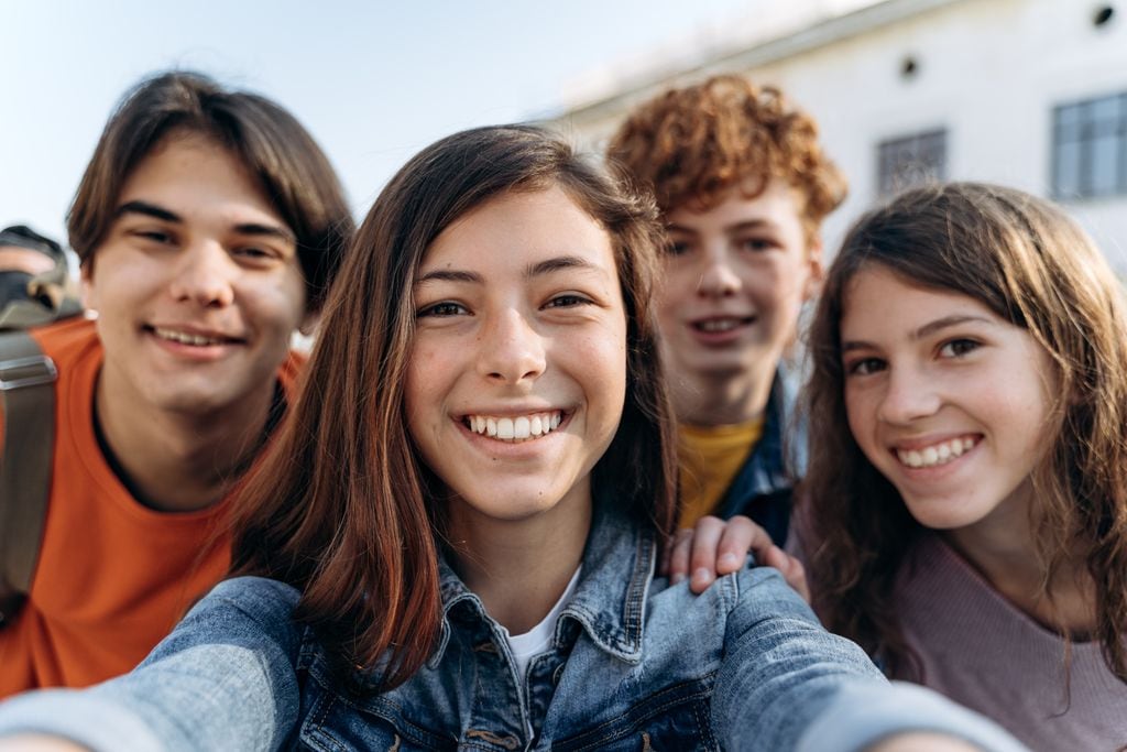 Grupo de adolescentes felices mirando a cámara
