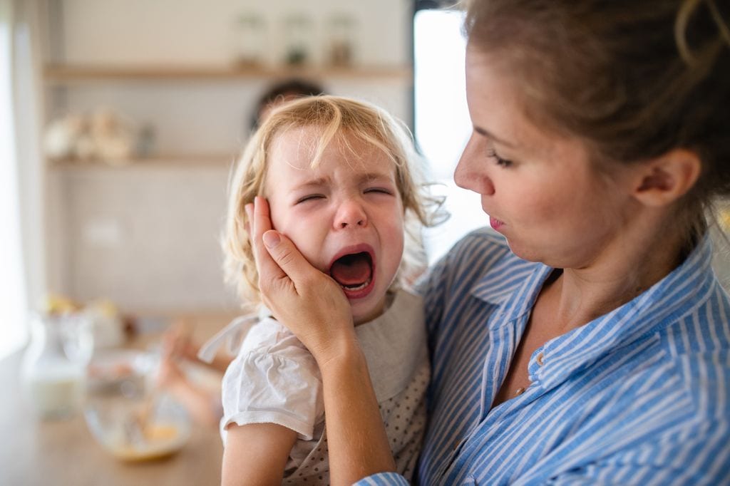 Una madre intenta calmar una rabieta de su hija