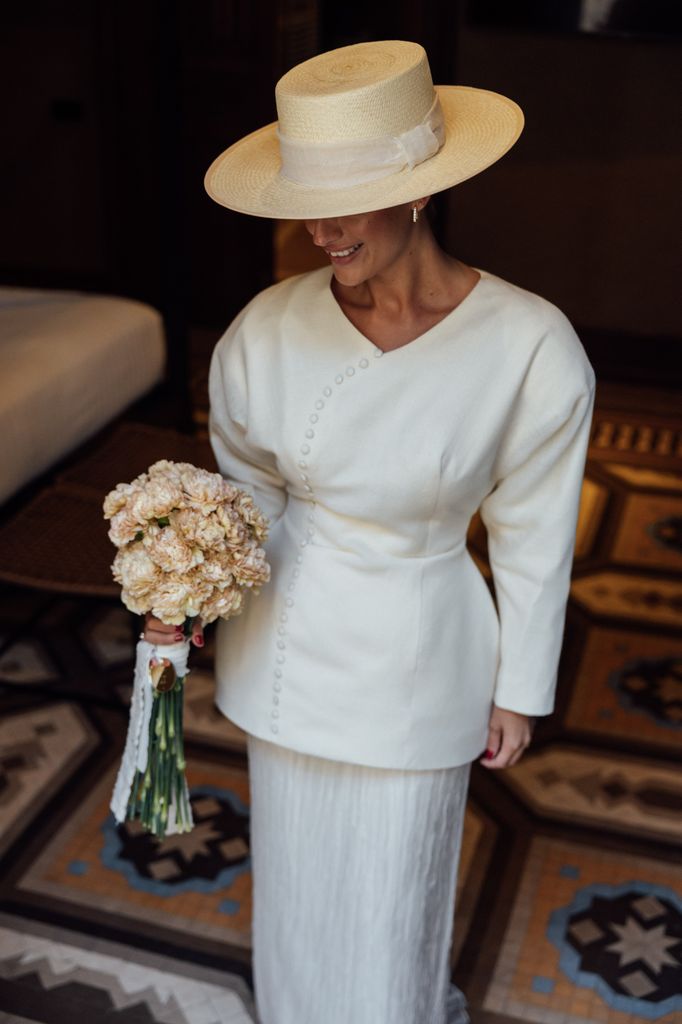 Vestido de novia de Toni Santón con sombrero cordobés y ramo de claveles