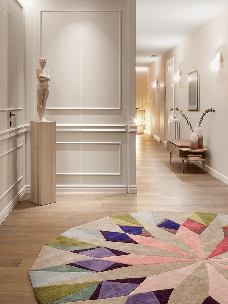 Espacio decorado con molduras y una alfombra redonda