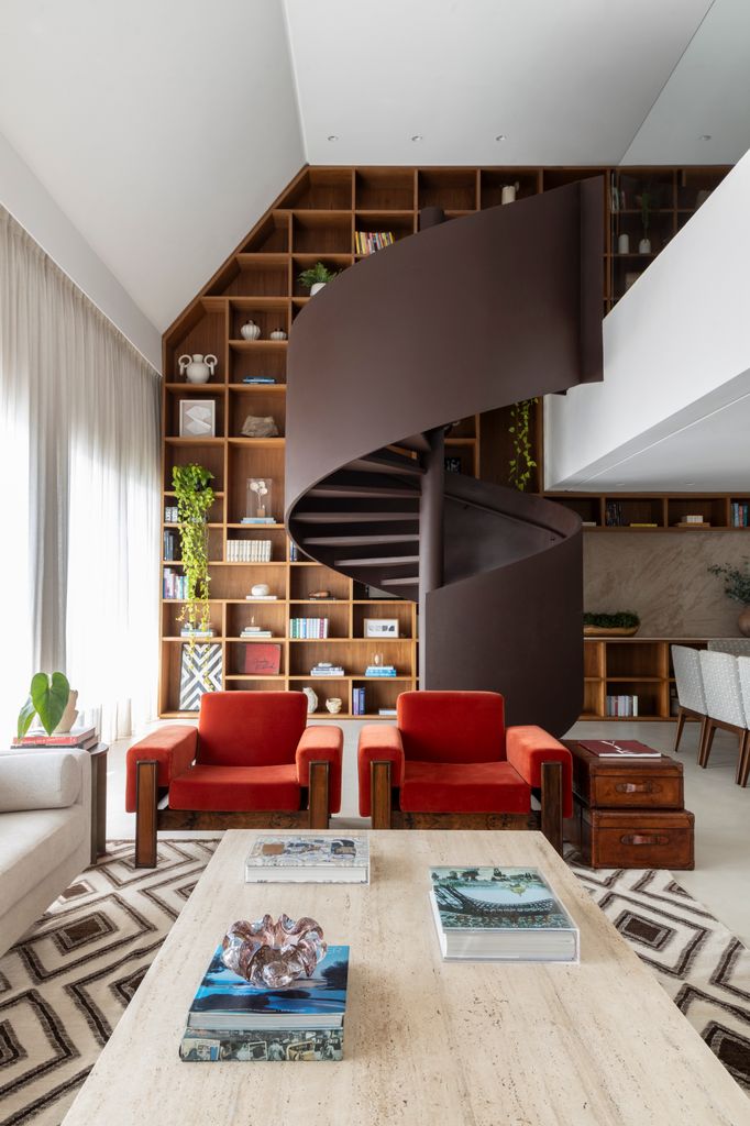 Salón con librería de suelo a techo y escalera helicoidal