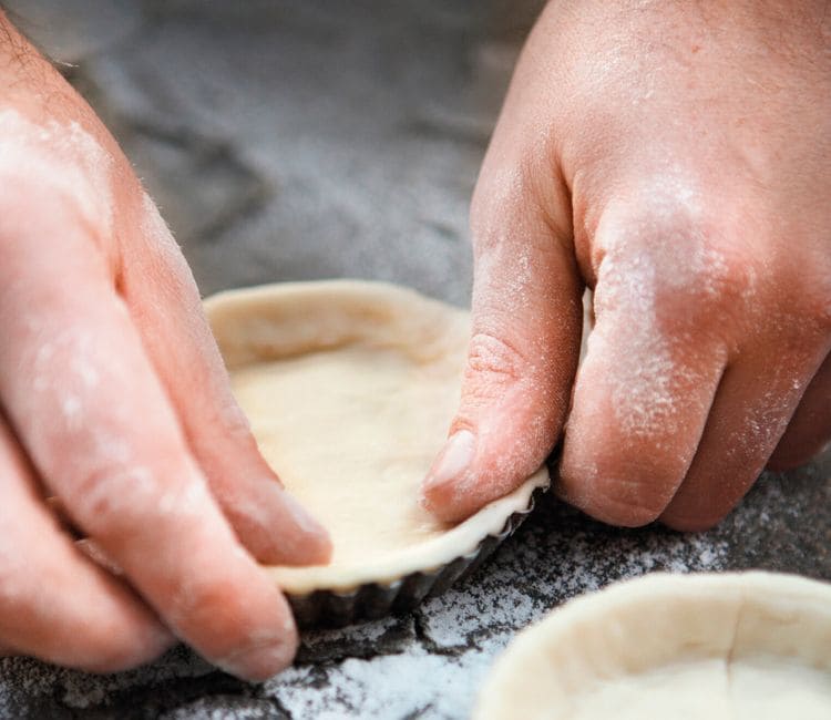 Manos ajustado masa sablé en un molde