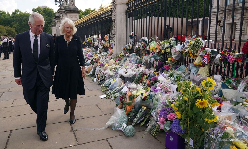 TOPSHOT - Britain\'s King Charles III and Britain\'s Camilla, Queen Consort view floral tributes left outside of Buckingham Palace in London, on September 9, 2022