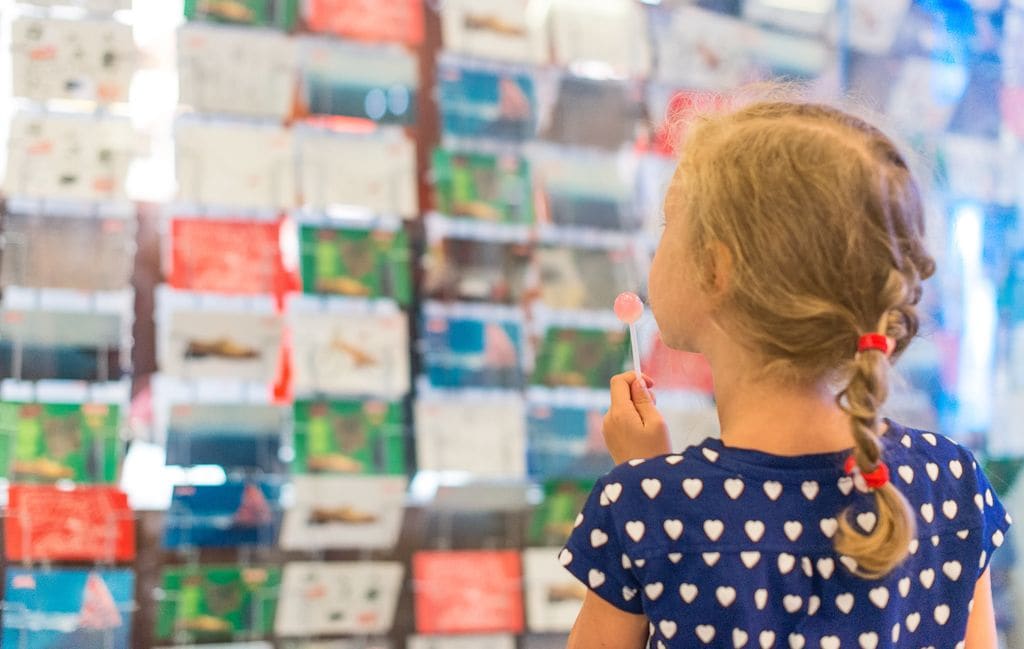 Niña eligiendo postales en una tienda