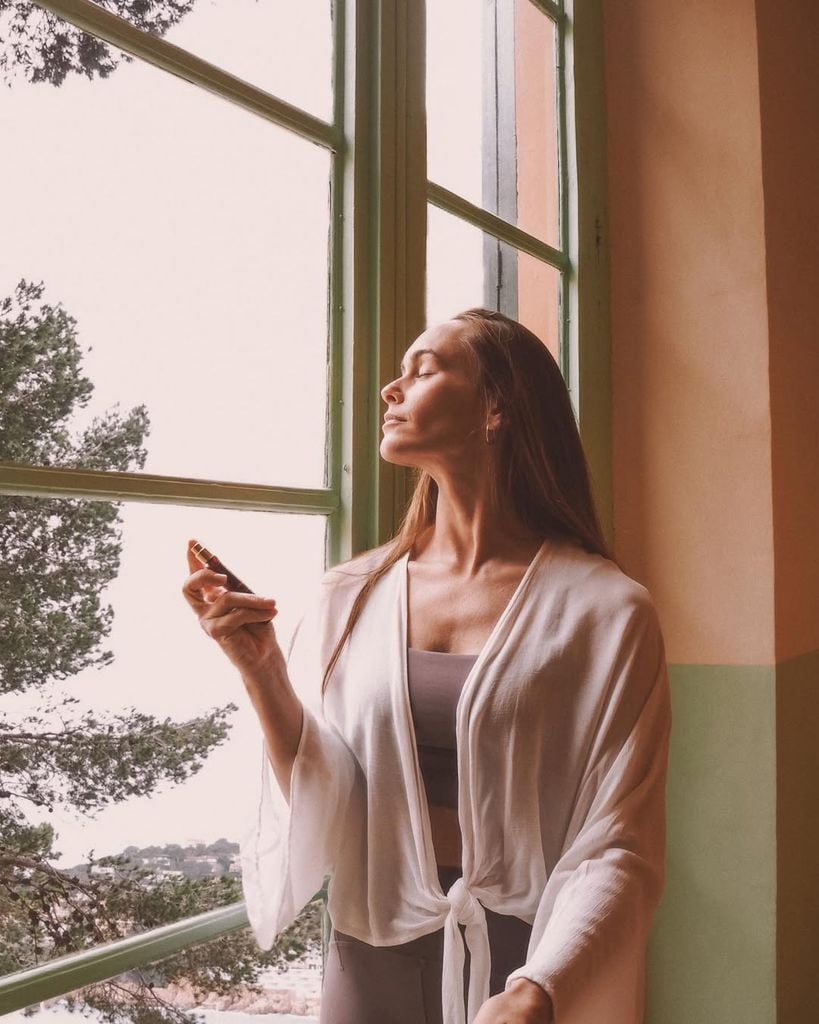 Mujer con kimono de lino frente a una ventana abierta