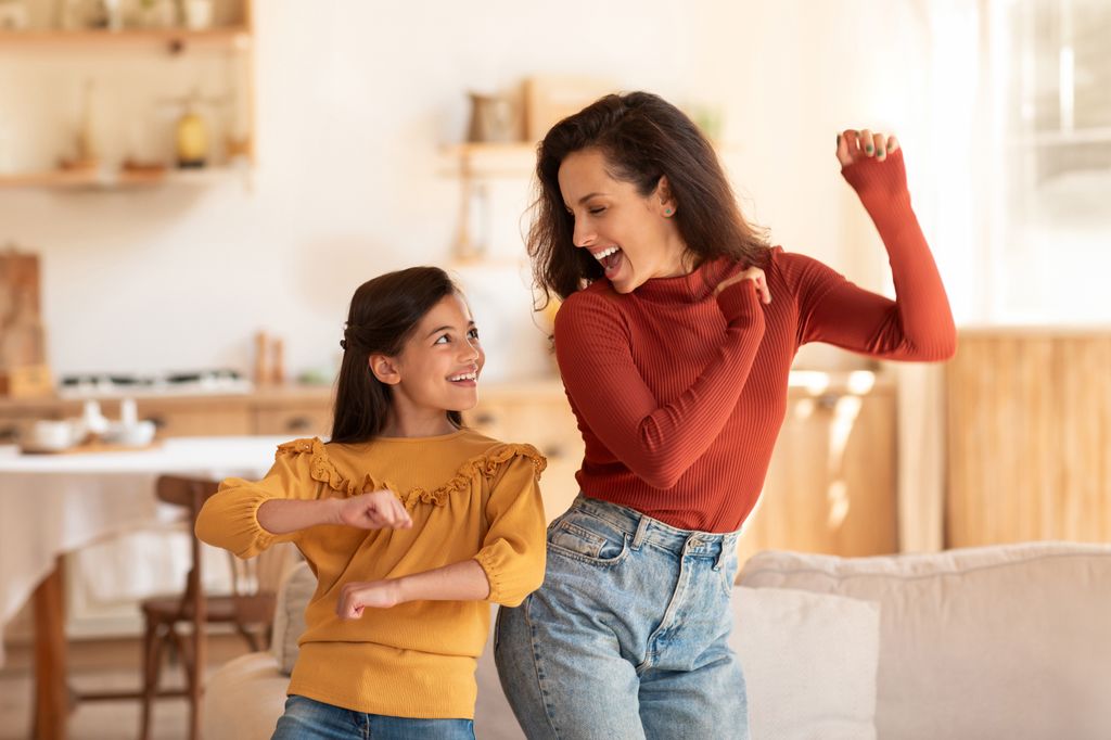 Madre e hija bailando juntas felices
