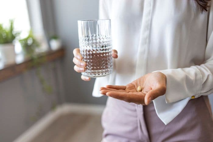 mujer con pastillas en la mano