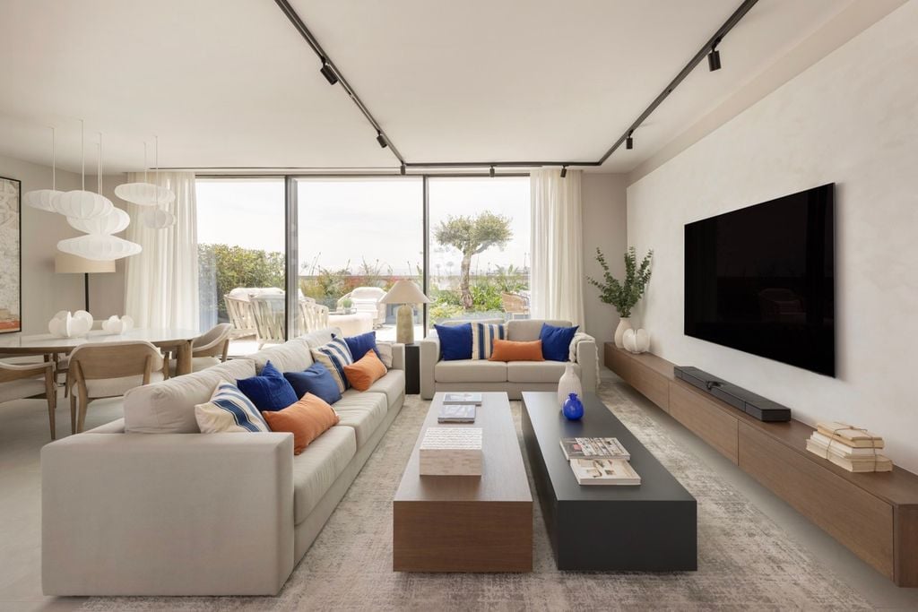 Salón con sofás blancos y cojines de colores. 