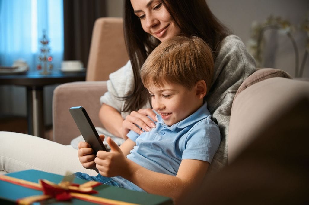 Niño pequeño recibiendo un móvil de regalo