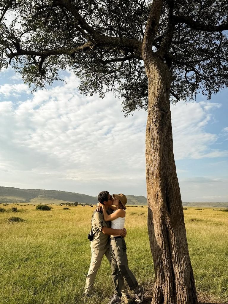 En esta imagen, la pareja se besa con una manada de elefantes en el horizonte.