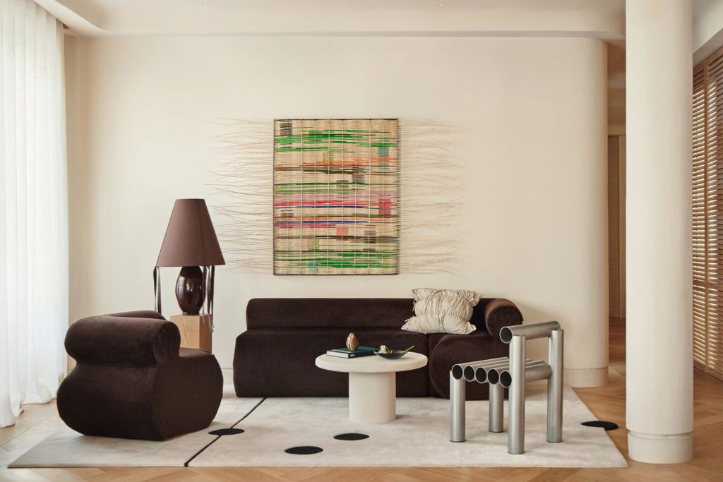 Salón con sofás negros y obra de arte en la pared
