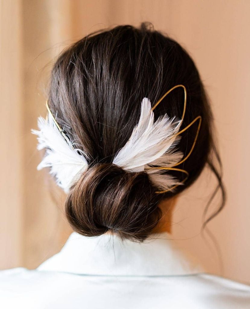 Moño joya peinado para novias con plumas