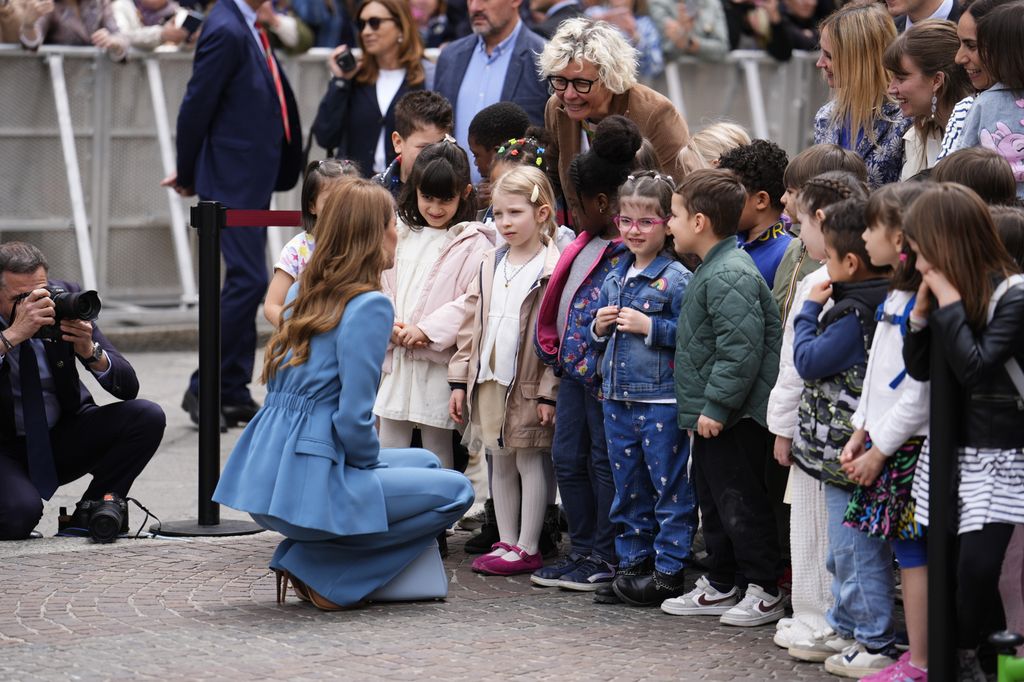 La princesa se ha agachado para hablar con un grupo de niños que la esperaban 