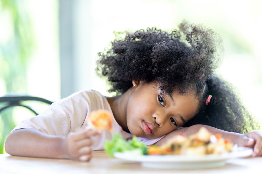 Niña con TCA delante de un plato de comida que no quiere