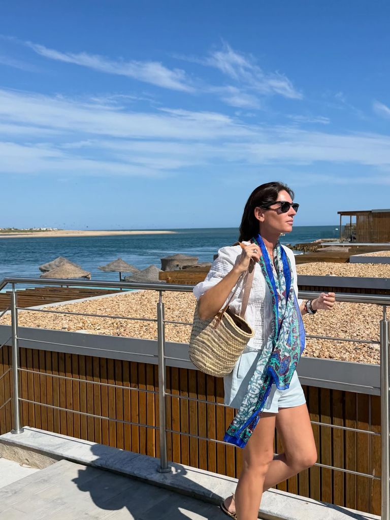 Con una blusa blanca, shorts azul bebé, un capazo y un pañuelo estampado, Lourdes volvió a demostrar por qué su estilo relajado se ha convertido en una de sus señas de identidad cada verano.