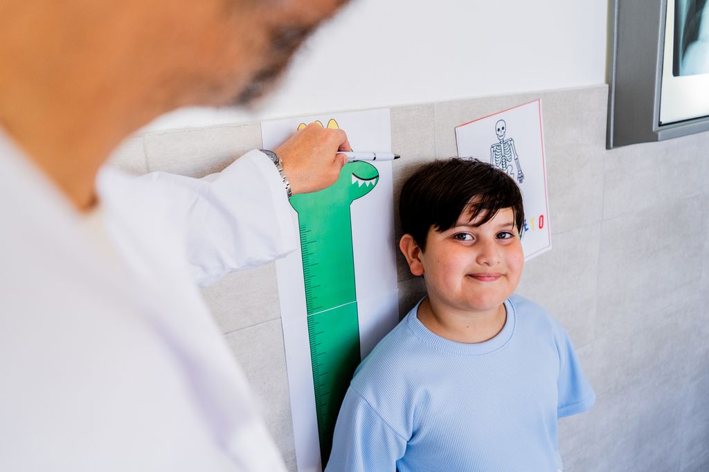 Niño en consulta del médico mientras lo miden
