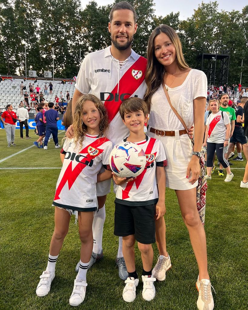 Malena Costa y Mario Suárez posan con sus hijos en el campo del Rayo Vallecano