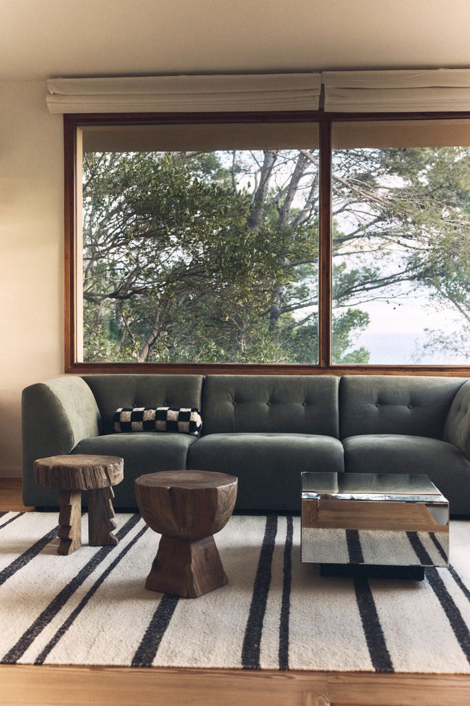 Salón con sofá verde y tres mesas de centro diferentes